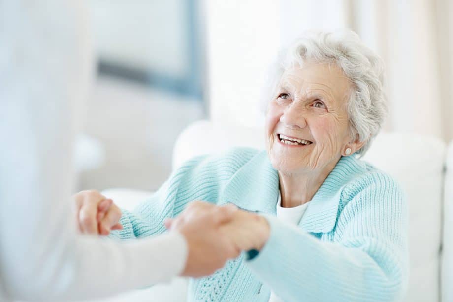 elderly woman holds hands