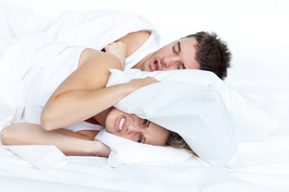 woman trying to sleep while man snores