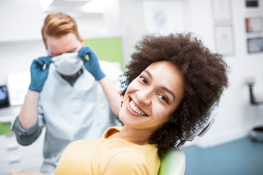 a woman smiles in a dental chair