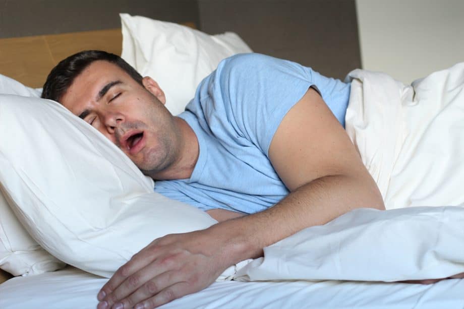 man in bed snores with mouth open